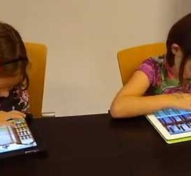 Fotografía de dos niñas pequeñas usando mediante dispositivos tablet la aplicación del videojuego ATO desarrollado por los informáticos de la Universidad de Granada