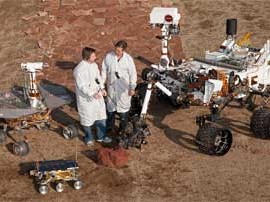 Un investigador junto a otro y el robot Curiosity